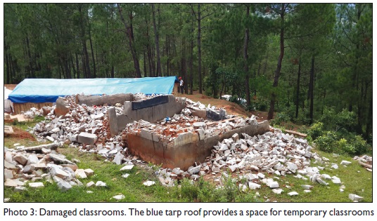 Damaged classrooms. The blue tarp roof provides a space for temporary classrooms